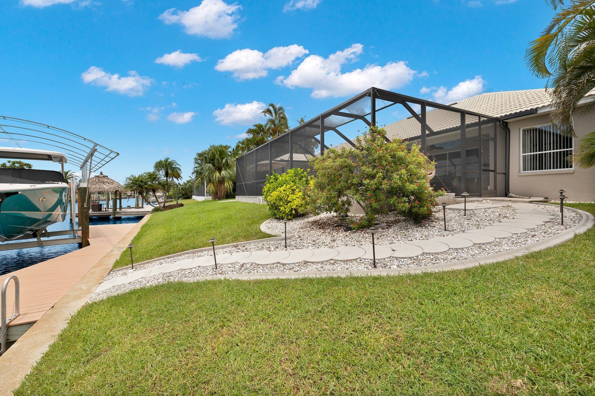 A modern outdoor area with a pool, a covered patio, and a well-maintained lawn.