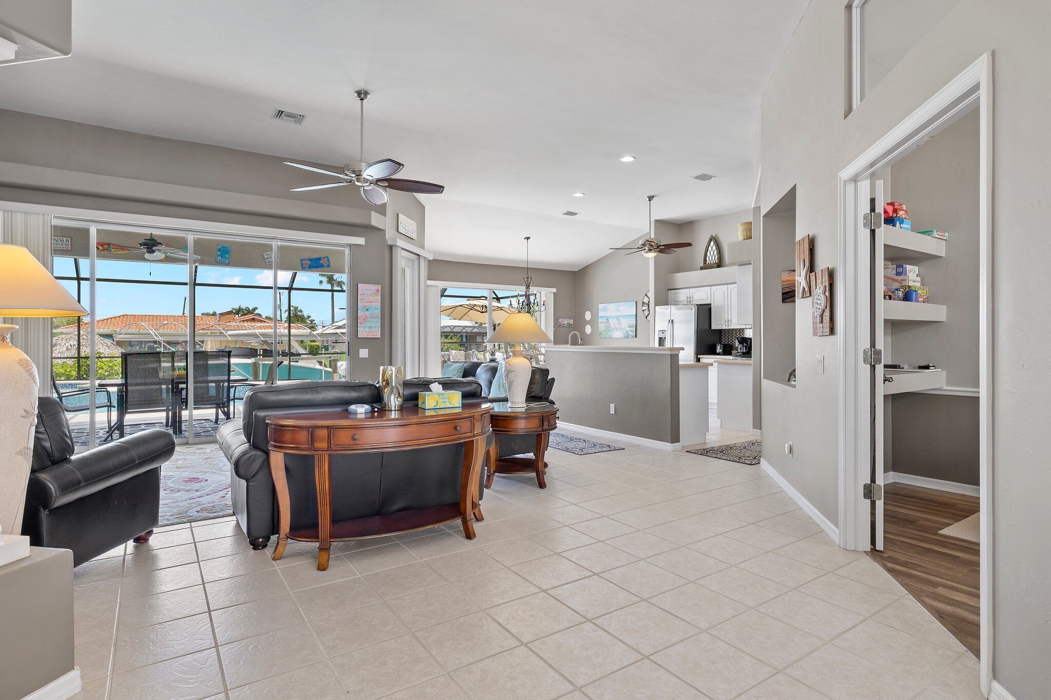 A spacious living area with a dining table, two sofas, and a ceiling fan.
