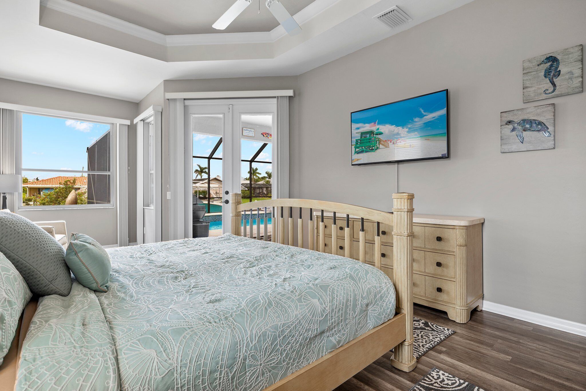A bedroom with a bed, a dresser, and a television.