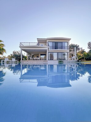 A modern two-story house with a large swimming pool in front. - Huzur villa  (Izmir)