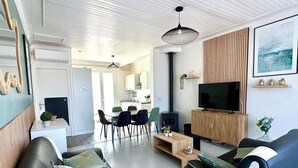 Ein modernes Wohnzimmer mit einer schwarzen Ledersofa, einem Holzschrank und einem Flachbildfernseher.