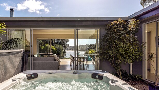 A hot tub with a view of a dining area and a pool. - Bonnie Doon l Be My Guest Waiheke  (Waiheke Island)