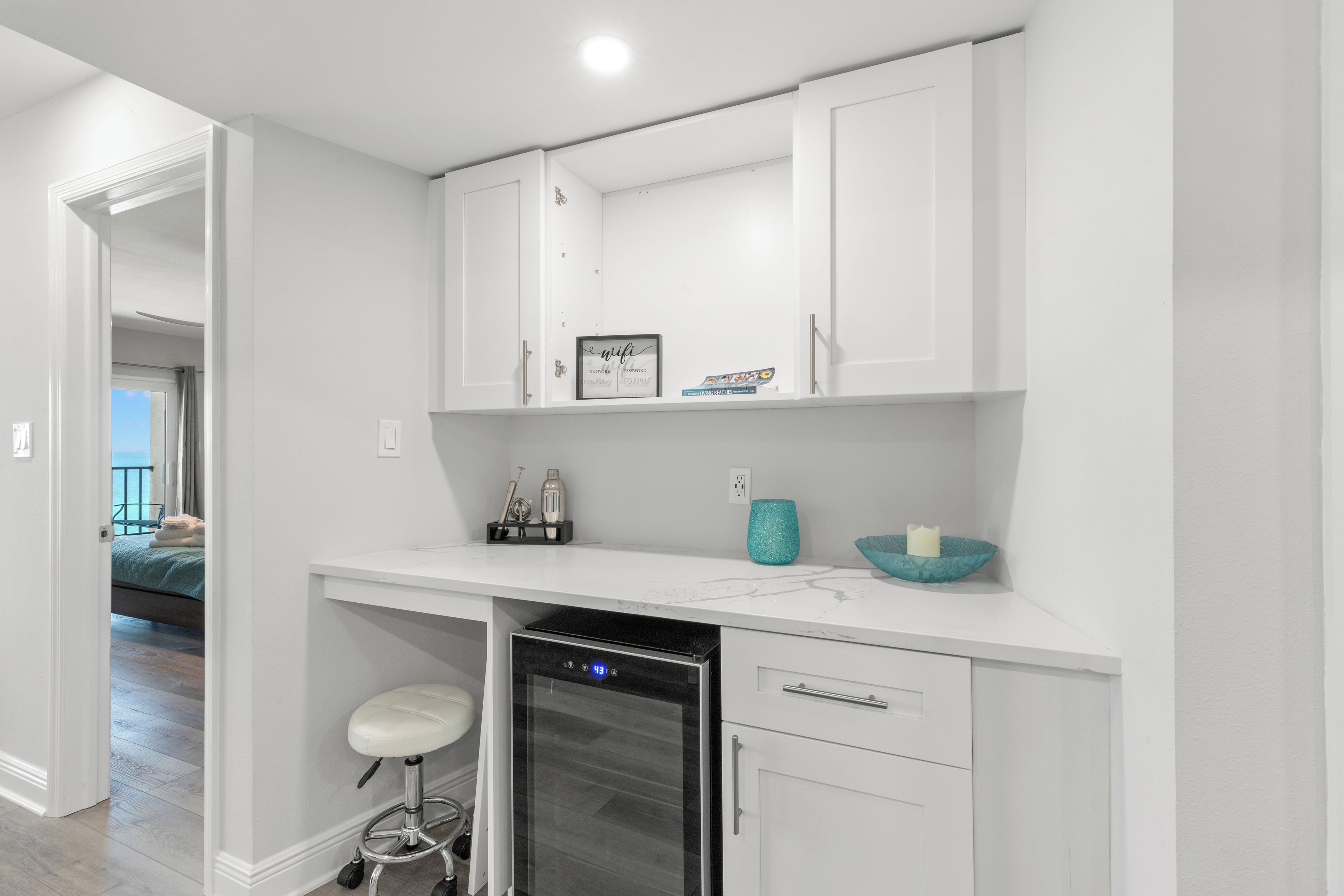 A modern kitchen with white cabinetry, a built-in oven, and a countertop with a sink and a small island.