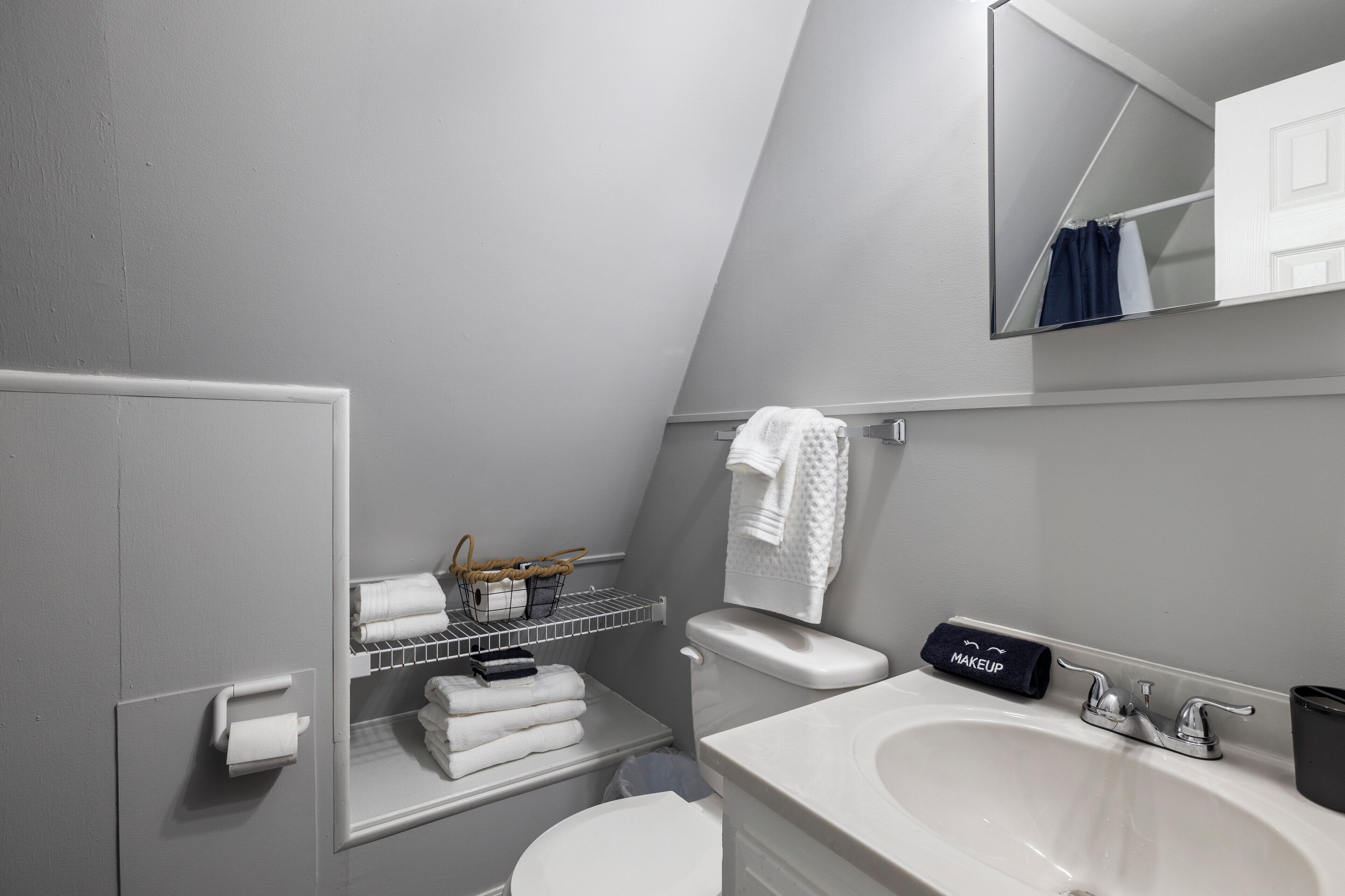 A modern bathroom with a white sink, a toilet, and a towel rack.