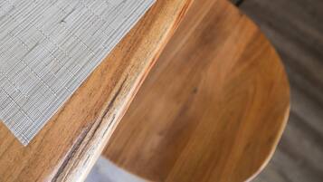 Une table en bois avec une assiette blanche et une serviette noire.