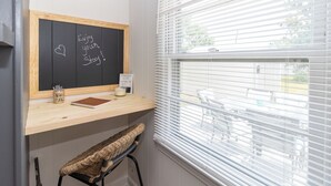 A room with a wooden desk, a chalkboard with motivational writing, a candle, and a wicker bench. - 2 bed/1 ba-across f/Coliseum/GAC (Greensboro)