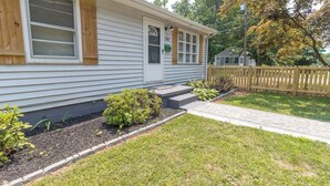 A single-story house with a front porch, a small garden, and a wooden fence. - 2 bed/1 ba-across f/Coliseum/GAC (Greensboro)