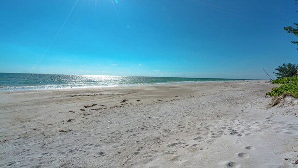 A beach with footprints in the sand and a clear blue sky. - Shore Haven Unit 5A by Distinctive Beach Rentals (Indian Shores)