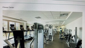 Una palestra con tapis roulant, macchinari per l'allenamento con i pesi e attrezzature per esercizi.