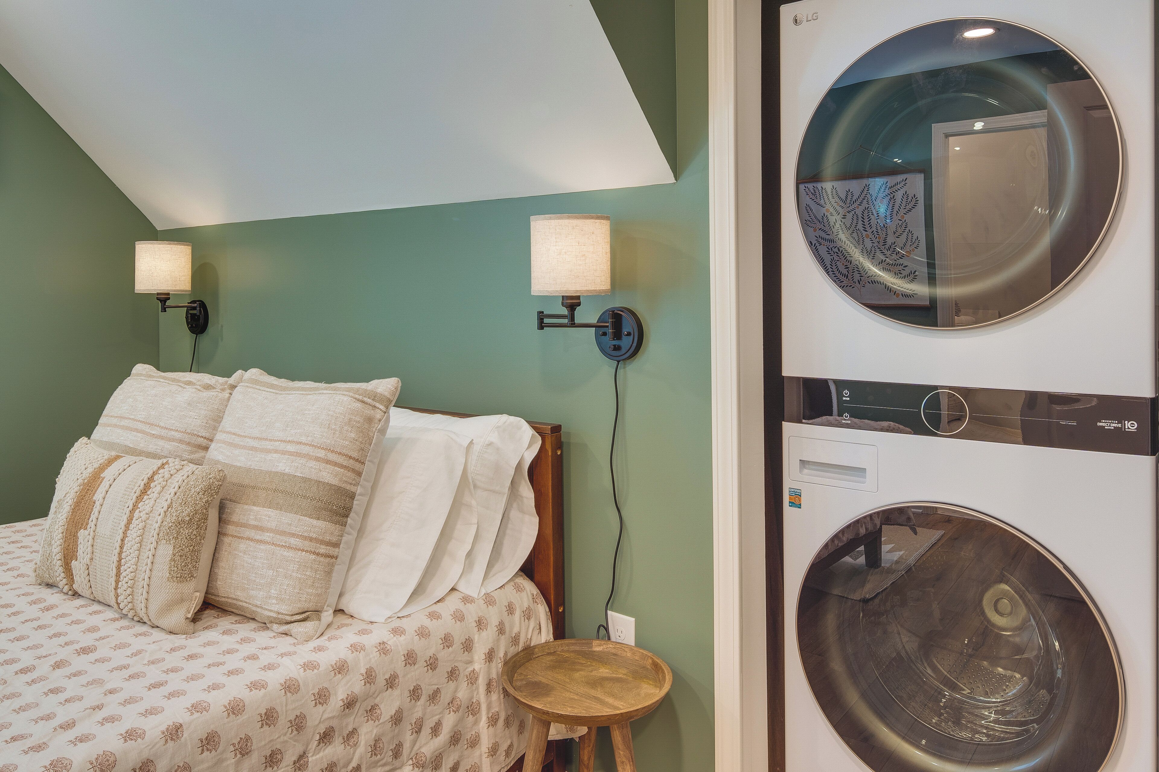 Una camera da letto con un letto, due lampade a parete e una lavatrice.