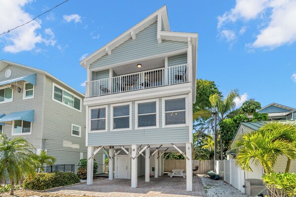 A two-story house with a balcony, a covered patio, and a number 18 sign.