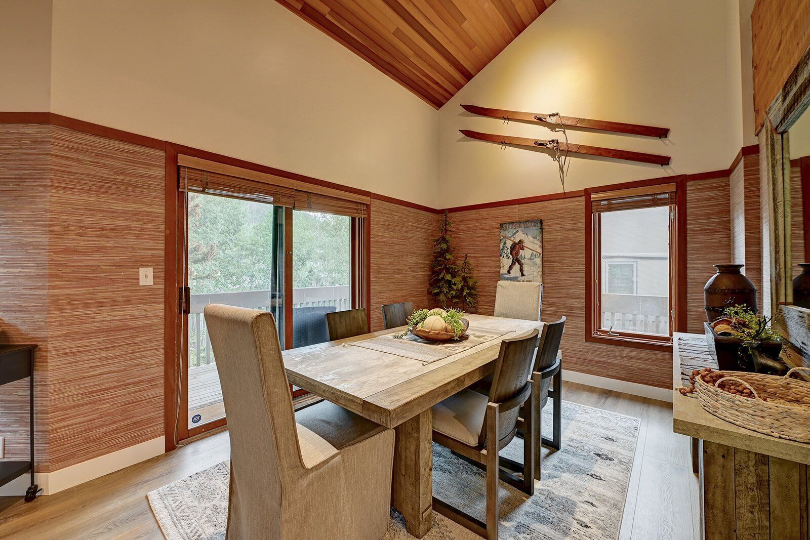 A dining area with a wooden table, chairs, and a ceiling fan.