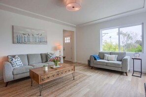 A living room with two sofas, a coffee table, a lamp, and a painting on the wall.
