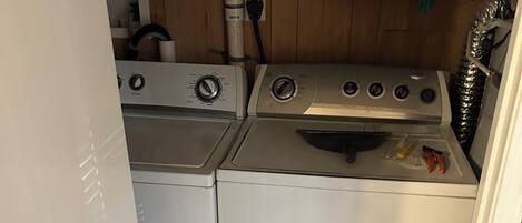A compact laundry room with two washing machines and a dryer.