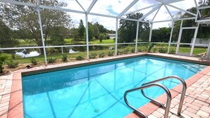 A swimming pool with a metal ladder, surrounded by a brick patio and a white canopy structure. - Emerald House : Free Amazing Heated Pool !!!!! (Bradenton)