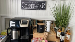 A coffee bar setup with a Hamilton Beach Flexbrew coffee maker, sugar dispenser, and various coffee pods. - 3 Blocks from Beach house 1 BDRM full bath 4 min to downtown,sleeps 4 (Sheboygan)