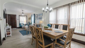 A dining area with a wooden table and chairs, a chandelier, and a view through large windows. - 3 Blocks from Beach house 1 BDRM full bath 4 min to downtown,sleeps 4 (Sheboygan)