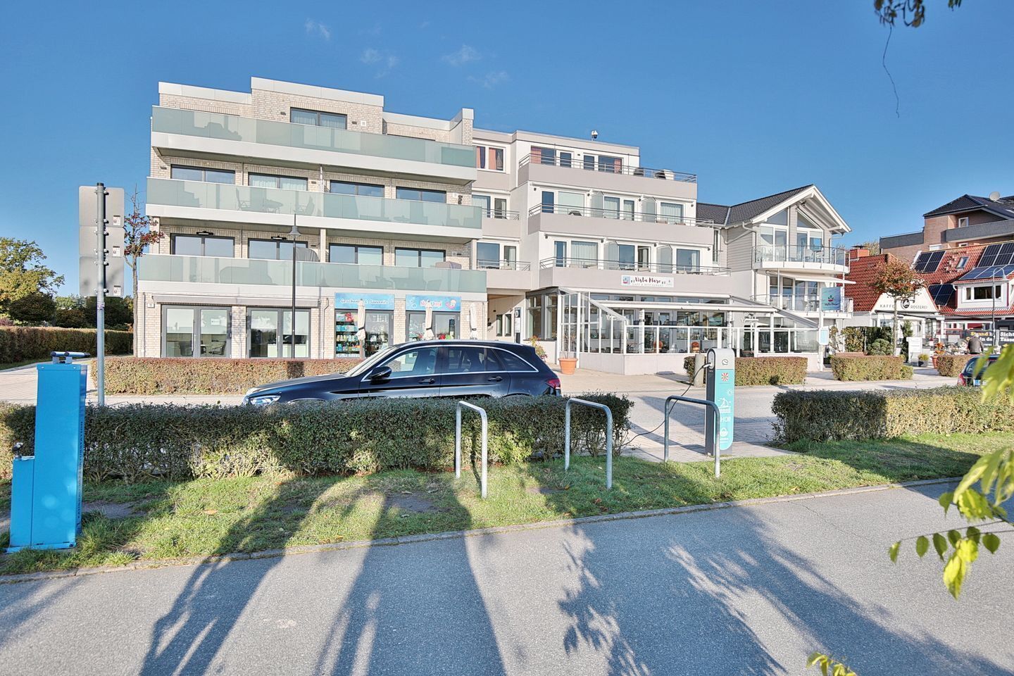 A modern building with multiple floors, large windows, and a covered entrance area.