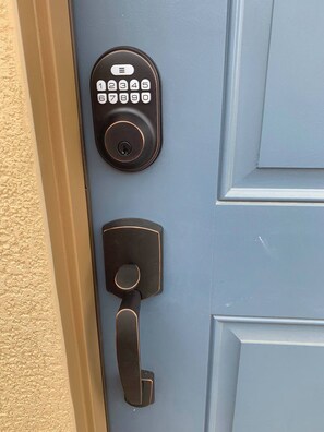 Una puerta con un moderno teclado electrónico y una cerradura tradicional.