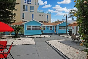 A blue building with a patio area, outdoor seating, and a flag.