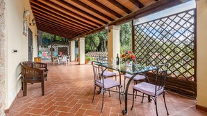An outdoor patio with a glass table, chairs, and a bottle of wine. - Beautiful home in Monteverdi M.mo PI (Monteverdi M.mo PI)
