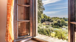 A view from a window with wooden shutters, overlooking a house surrounded by trees and a clear sky. - Beautiful home in Monteverdi M.mo PI (Monteverdi M.mo PI)