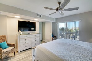 A bedroom with a bed, a TV on a dresser, a ceiling fan, and a balcony with a view. - El Matador 430 - FREE TICKETS!! Your stay includes free tickets to many area attractions! (Fort Walton Beach)