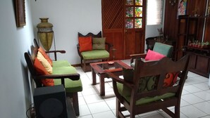 Ein Wohnzimmer mit einer Sofagarnitur, einem Couchtisch und einem Lautsprecher.