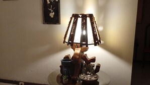 Ein Zimmer mit einem runden Holztisch, einer Lampe, einem kleinen Topfpflanzen und einer dekorativen Schale.