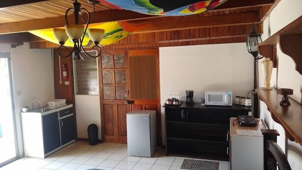 Eine kleine Küche mit Kühlschrank, Mikrowelle und Spüle.