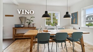 A modern kitchen with a wooden table and chairs, a large window, and a sign that reads "VINO". - Lovely home in Samsø with WiFi (Samsø)