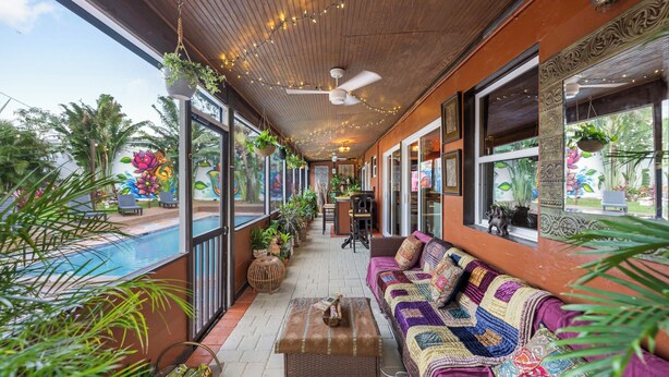 A covered outdoor area with a pool, seating, and hanging plants. - BOHO Paradise, KING Bed, POOL, 1 month+LONG Term Stays,PET FRIENDLY (Pompano Beach)