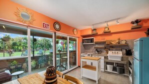 A kitchen with a blue refrigerator, white cabinets, and a dining area with a table and chairs. - BOHO Paradise, KING Bed, POOL, 1 month+LONG Term Stays,PET FRIENDLY (Pompano Beach)