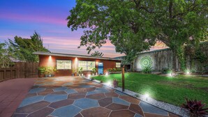 A well-maintained garden with a stone pathway leading to a house with a blue door. - BOHO Paradise, KING Bed, POOL, 1 month+LONG Term Stays,PET FRIENDLY (Pompano Beach)