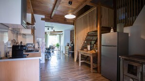 Eine Küche mit Holzböden, einem Kühlschrank und einem Essbereich mit Stühlen und einem Tisch.