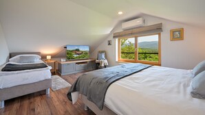 A bedroom with two beds, a TV, a desk, and a window with a view of a mountain. - Nice home in Stubicke Toplice with sauna (Stubicke Toplice)