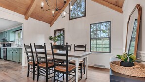 A dining area with a wooden ceiling, large windows, and a view of the outdoors. - Charming ranch in Wilmington (Wilmington)