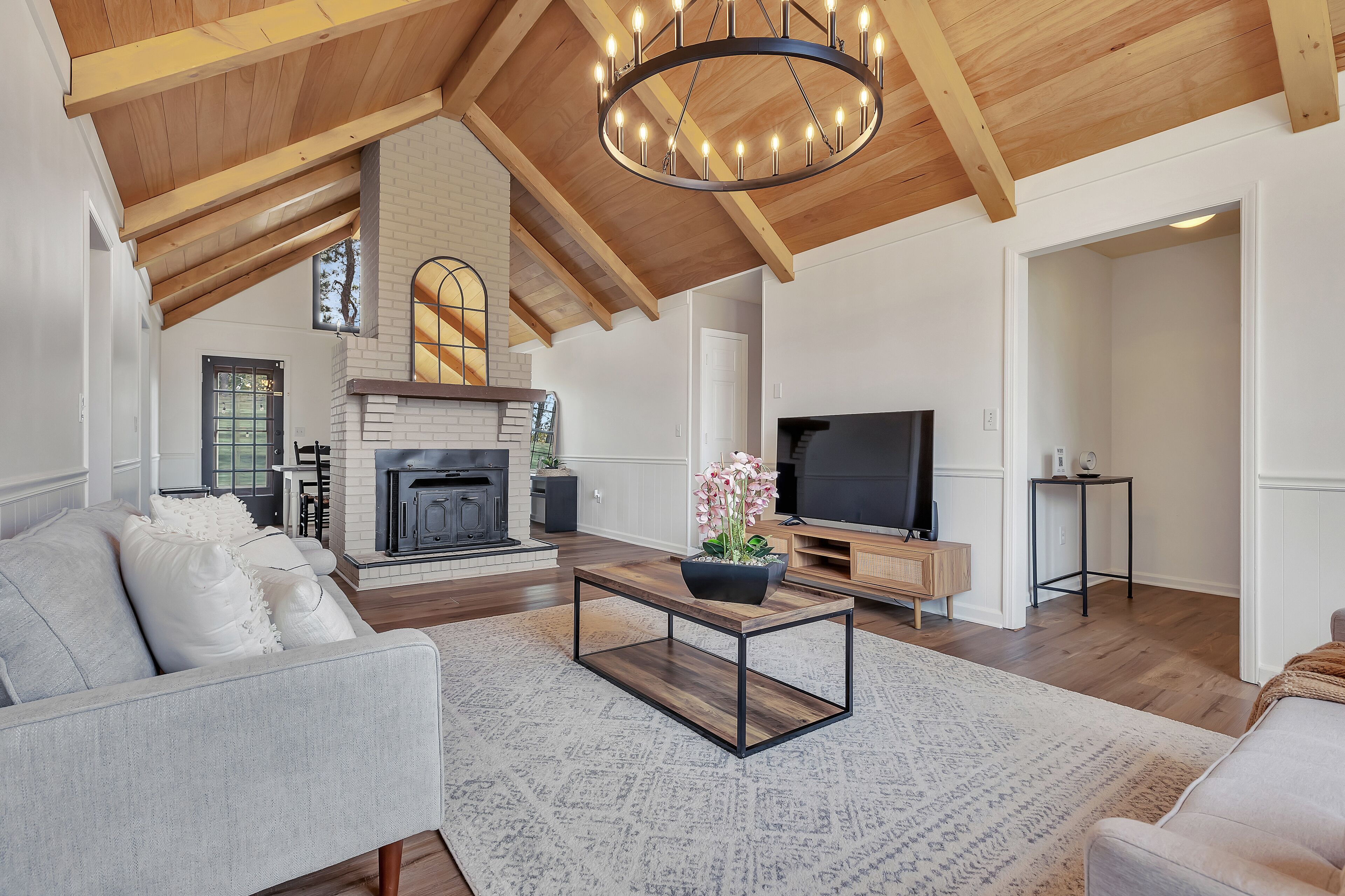 A spacious living room with a fireplace, a television, and a modern coffee table.