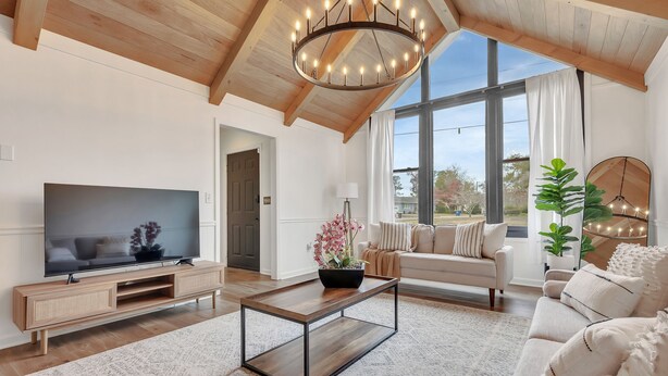 A spacious living room with a large TV, wooden entertainment unit, and a cozy sofa. - Charming ranch in Wilmington (Wilmington)