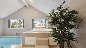 A modern bathroom with a built-in bathtub, a shower, and a large window. - Nice home in Krakow am See with sauna (Krakow am See)