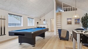 A pool table in a room with wooden floors, a blue pool table, a ladder, and a table with a foosball table. - Nice home in Krakow am See with sauna (Krakow am See)