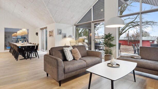A modern living room with a sofa, coffee table, and dining area. - Nice home in Krakow am See with sauna (Krakow am See)