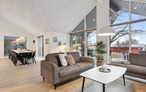 A modern living room with a sofa, coffee table, and dining area. - Nice home in Krakow am See with sauna (Krakow am See)