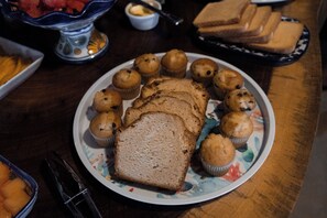 Um prato com muffins e fatias de pão sobre uma mesa.