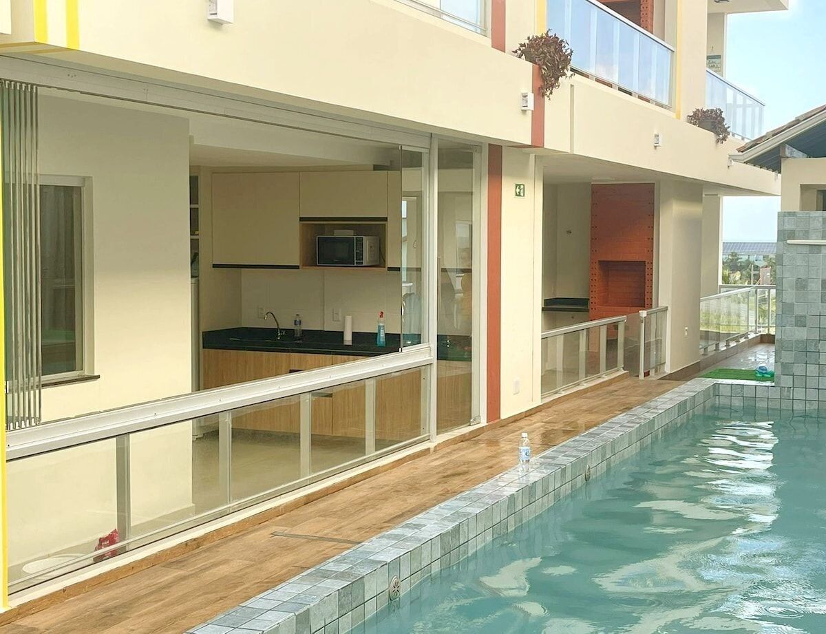 Un hotel moderno con piscina, zona de cocina y balcón con vistas.