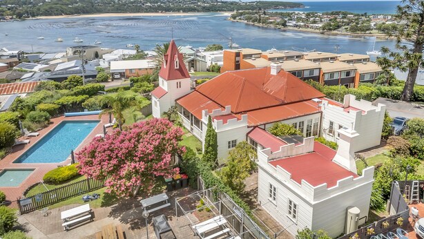 A coastal property with a swimming pool, a church with a red roof, and a view of the sea. - Munns Tower House- In the Heart of Merimbula (Merimbula)