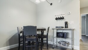 A dining area with a table and chairs, a coffee machine, and a metal cart with shelves. - EXCELLENT location!!  Walk to The Island. (Pigeon Forge)