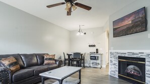 A living room with a sofa, coffee table, fireplace, and a painting on the wall. - EXCELLENT location!!  Walk to The Island. (Pigeon Forge)