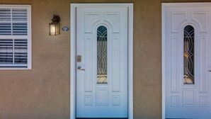 A white door with a glass panel and a small wall-mounted light fixture. - EXCELLENT location!!  Walk to The Island. (Pigeon Forge)