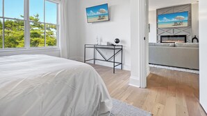A bedroom with a large bed, a desk, and a fireplace. - Luxury 2Bed w/ Amazing Views (Cornelius)
